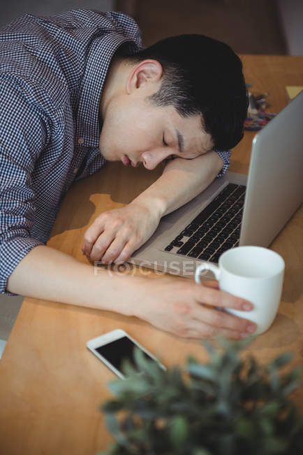 Geschäftsleiter schläft an seinem Schreibtisch im Büro — Stockfoto