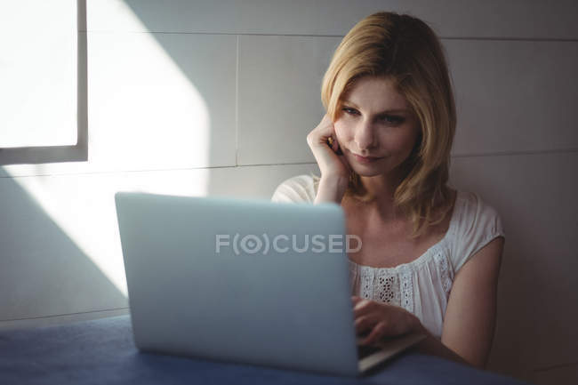 Schöne Frau mit Laptop im Wohnzimmer zu Hause — Stockfoto