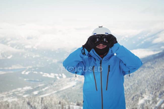 Skieur regardant la montagne à travers binoculaire — Photo de stock