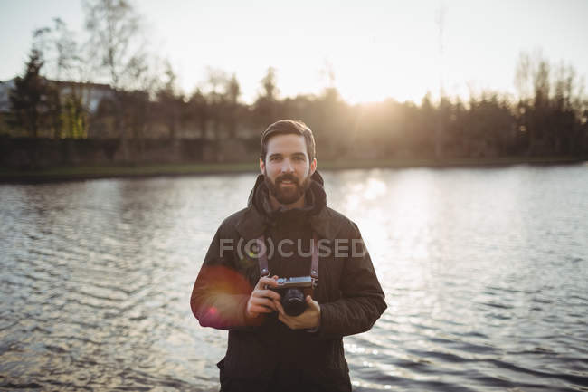 Mann hält Oldtimer-Kamera in Ufernähe — Stockfoto