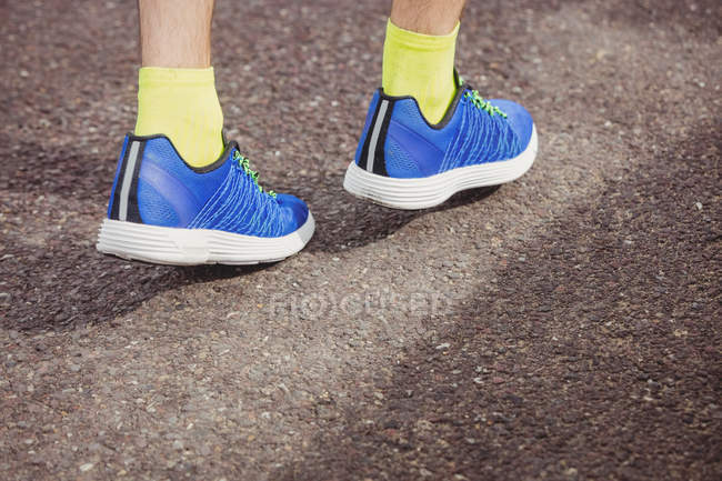 Low section of athlete walking on the road — Stock Photo