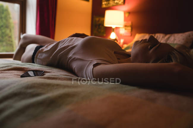 Frau liegt auf dem Bett im Schlafzimmer — Stockfoto