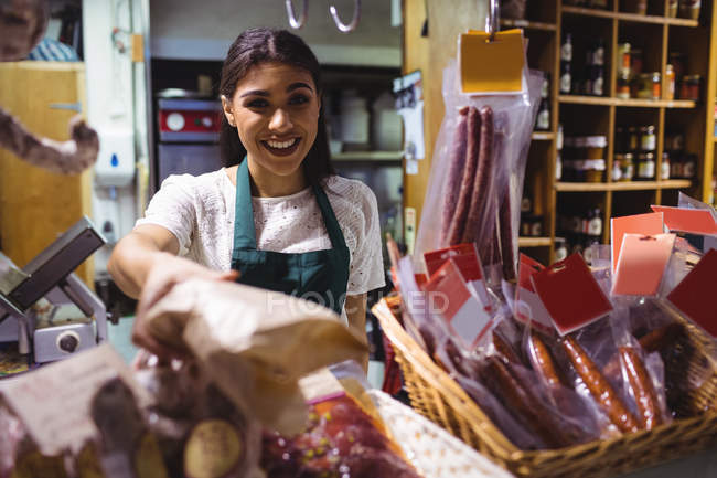 Personal femenino que trabaja en el mostrador de carne en el supermercado - foto de stock
