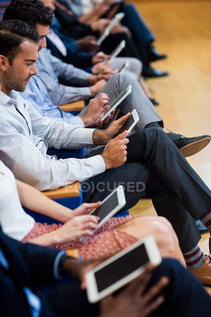 Бизнес-руководители, участвующие в бизнес-встрече с использованием цифрового планшета в конференц-центре — стоковое фото