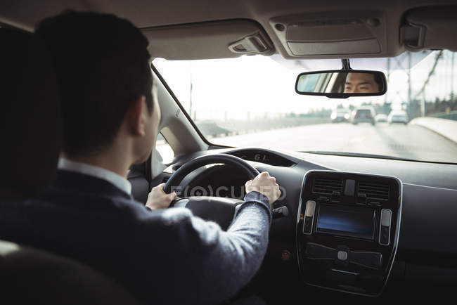 Rear view of young man driving electric car — Stock Photo