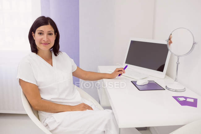 Portrait of dermatologist at desk in clinic — Stock Photo