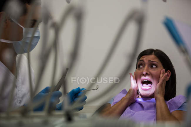 Paziente donna spaventata durante una visita odontoiatrica in clinica — Foto stock