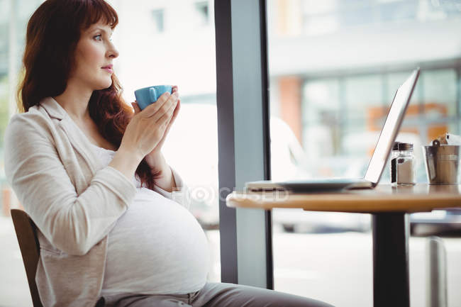 Schwangere Geschäftsfrau trinkt Kaffee in Büro-Cafeteria — Stockfoto