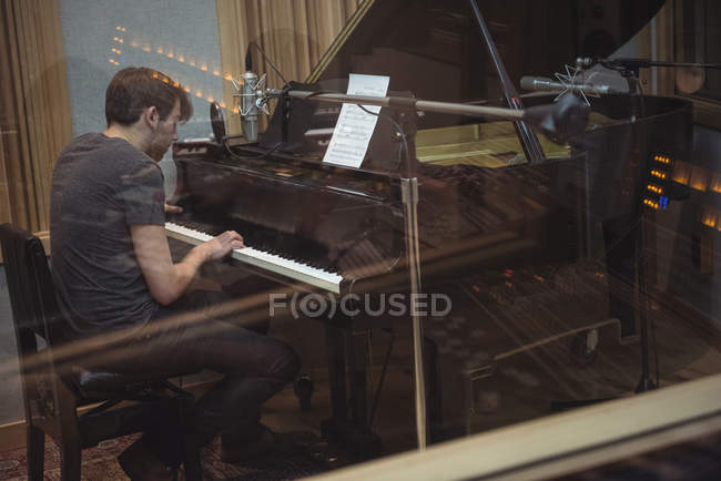 Homme jouant du piano dans un studio de musique — Photo de stock
