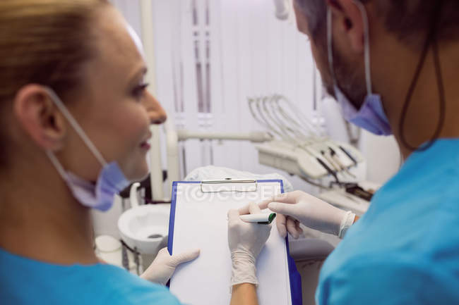 Dentistas interagindo uns com os outros na clínica dentária — Fotografia de Stock