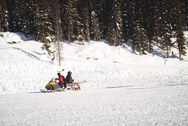 Sciatori in motoslitta in alpi innevate durante l'inverno — Foto stock