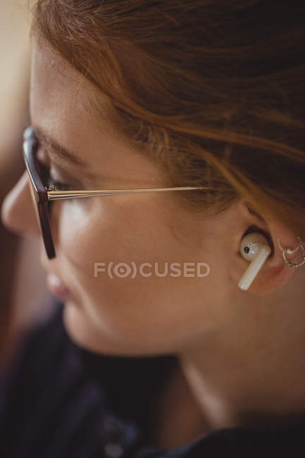 Primo piano di bella donna con auricolari wireless — Foto stock