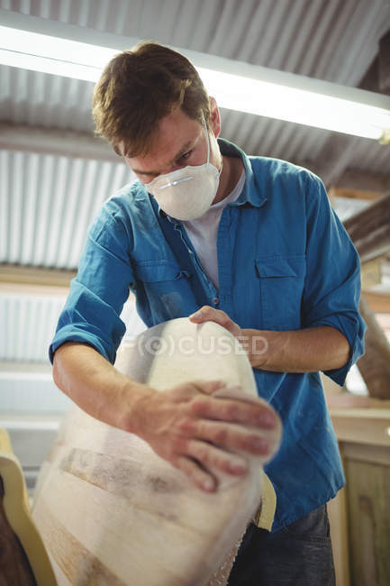 Young man making surfboard in workshop — Stock Photo