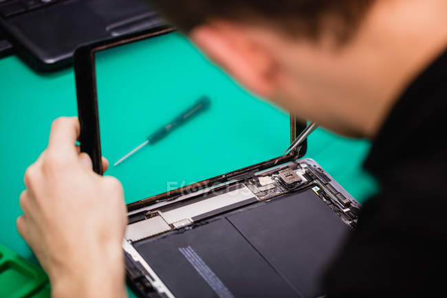 Mann repariert digitales Tablet in Reparaturzentrum — Stockfoto