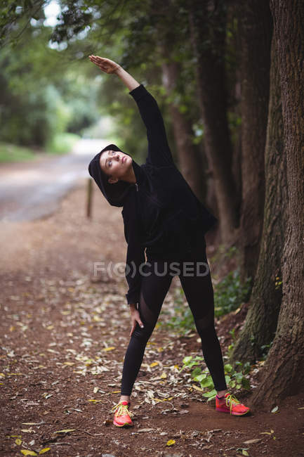 Donna che esegue esercizio di stretching nella foresta — Foto stock