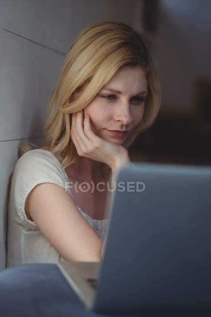 Hermosa mujer usando el ordenador portátil en la sala de estar en casa - foto de stock