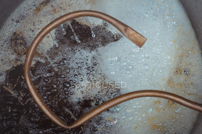 Close-up de tubo de cobre e mosto de cerveja fervente — Fotografia de Stock