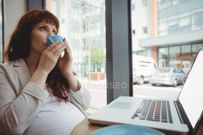 Вагітна бізнес-леді має каву в офісних кафетеріях — стокове фото