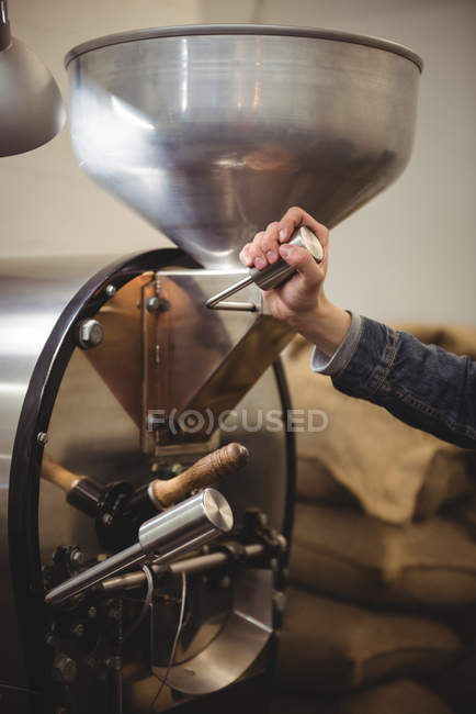Hand of man using coffee grinding machine in coffee shop — Stock Photo