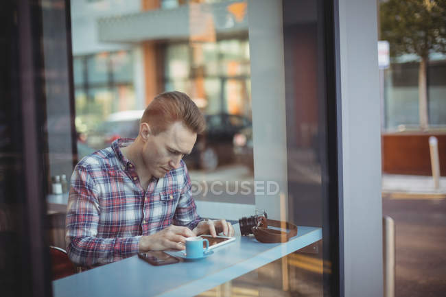 Молодой человек использует цифровые планшеты в кофейне — стоковое фото