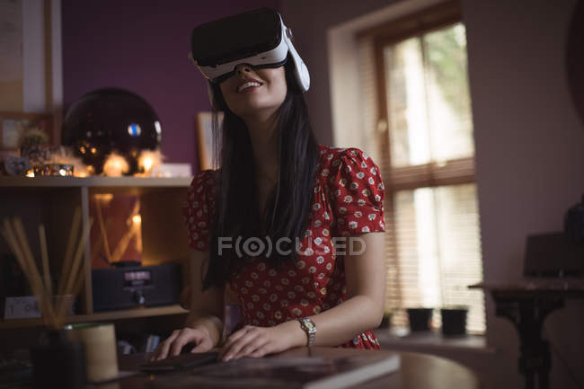 Жінка використовує гарнітуру віртуальної реальності вдома — стокове фото