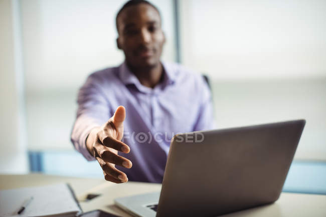 Executivo de negócios gesticulando um aperto de mão no escritório — Fotografia de Stock