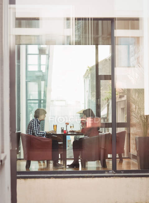 Casal tomando bebidas juntos no interior do restaurante — Fotografia de Stock