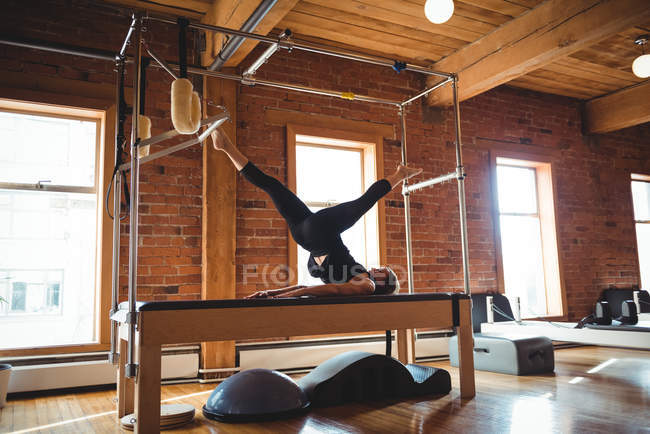 Гнучка жінка практикує пілатес у фітнес-студії — стокове фото