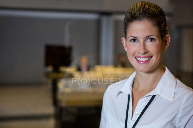 Portrait of smiling female staff standing at airport — Stock Photo