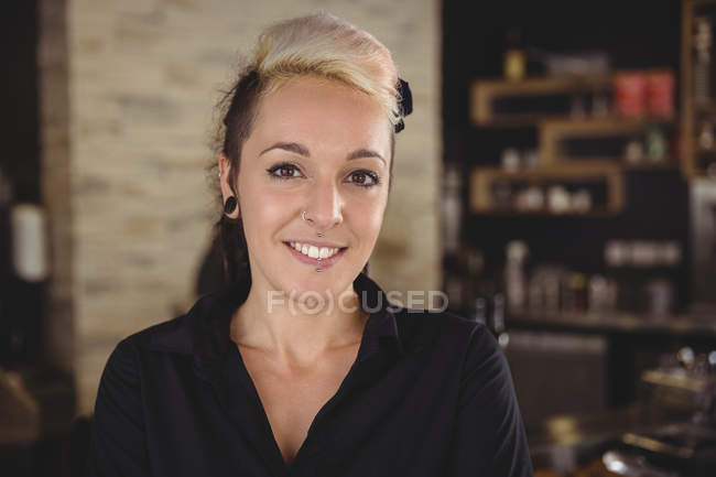 Retrato de la mujer sonriendo en la cocina en la cafetería - foto de stock