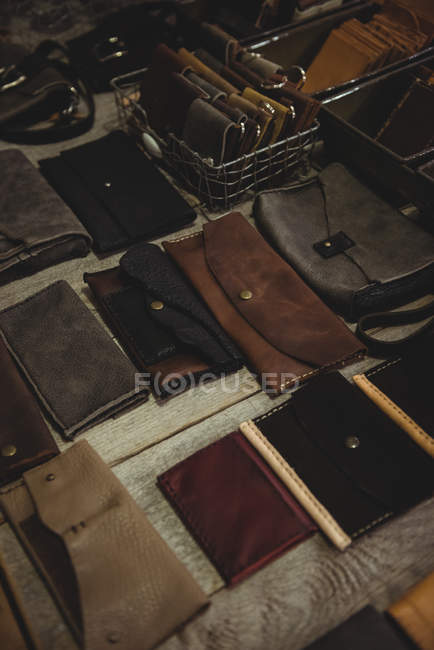 Различные кожаные кошельки на столе в мастерской — стоковое фото