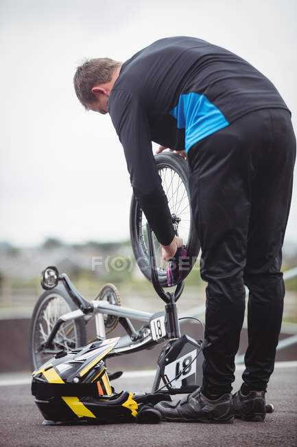 Ciclista che ripara una bici BMX nello skatepark — Foto stock