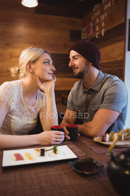 Casal romântico tendo saquê bebidas no restaurante — Fotografia de Stock