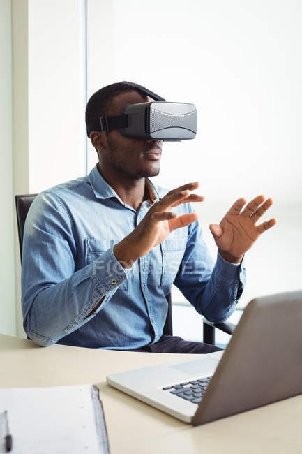 Бизнес-руководитель с помощью гарнитуры виртуальной реальности в офисе — стоковое фото