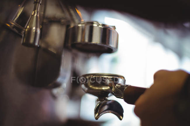 Serveuse tenant portafilter rempli de café moulu dans le café — Photo de stock