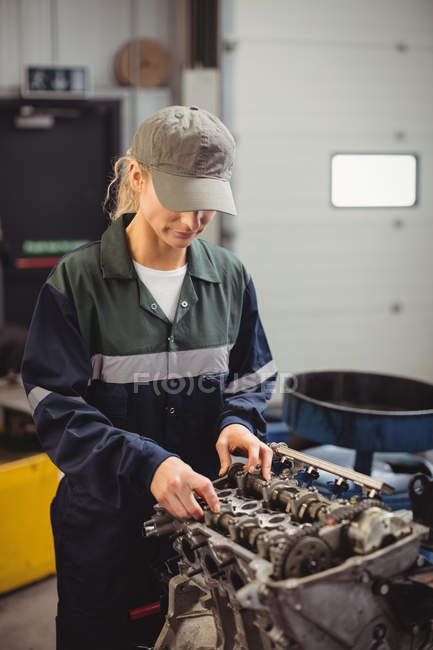 Female mechanic checking a car parts in repair garage — Stock Photo