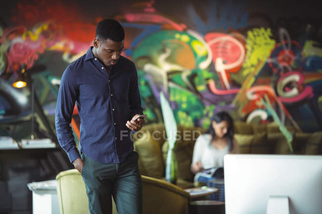 Бізнесмен, використовуючи мобільний телефон в офісі — стокове фото