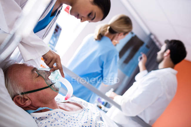 Medico femminile che mette la maschera di ossigeno sul viso del paziente in ospedale — Foto stock