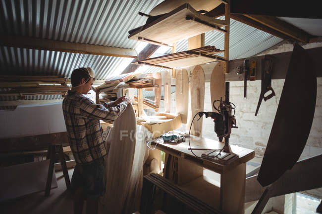 Homme faisant planche de surf à l'intérieur de l'atelier — Photo de stock