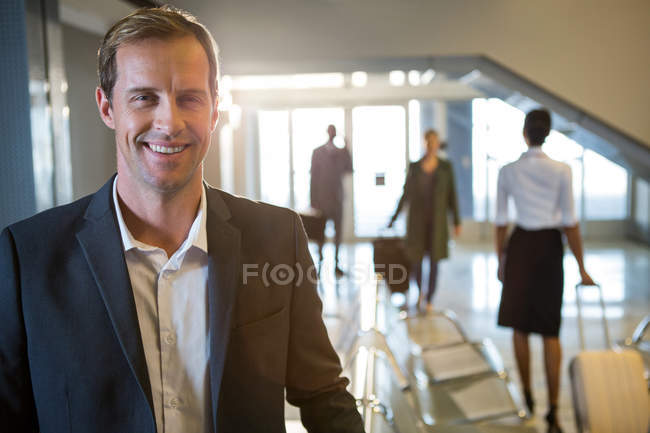 Портрет бизнесмена, улыбающегося в терминале аэропорта — стоковое фото