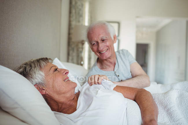 Счастливая старшая пара лежит на кровати в спальне — стоковое фото