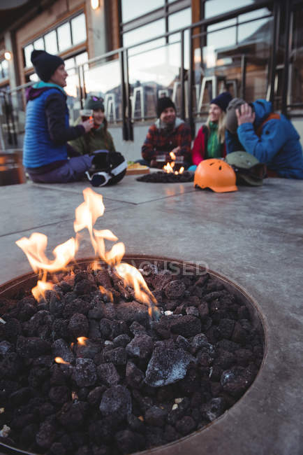 Grupo de esquiadores sentados en la chimenea de la estación de esquí - foto de stock