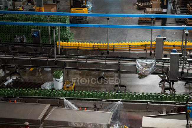 Vue grand angle des bouteilles sur les lignes de production dans l'usine de jus — Photo de stock