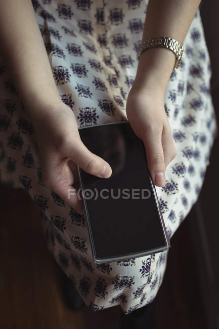 Primer plano de la mujer usando el teléfono móvil en la cafetería - foto de stock