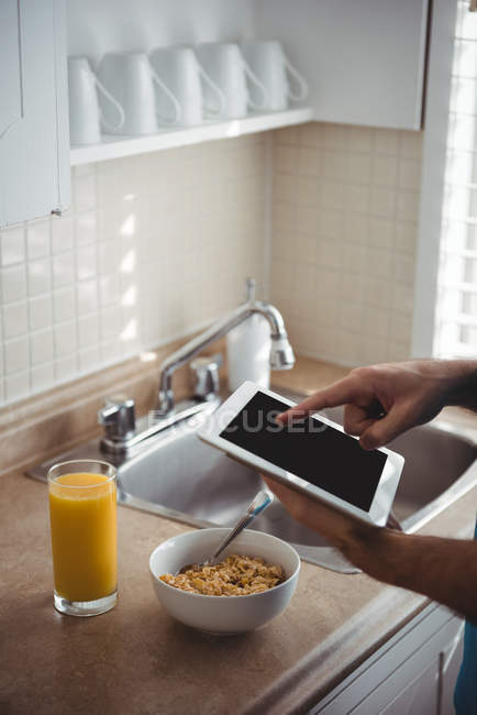 No meio da seção do homem usando seu tablet digital na cozinha em casa — Fotografia de Stock