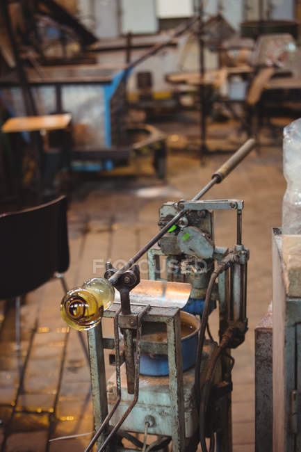 Molten glass on blowpipe on marver table at glassblowing factory — Stock Photo