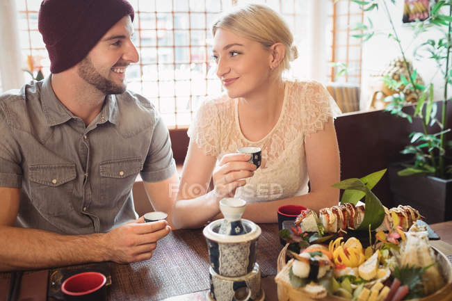 Couple interacting with each other while having tea in restaurant — Stock Photo
