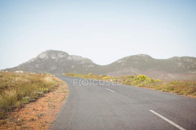 Strada di campagna che attraversa il paesaggio rurale in montagna — Foto stock