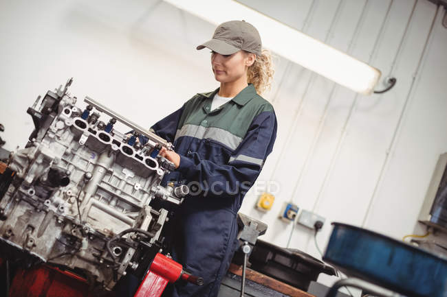 Feminino mecânico verificando um carro peças na garagem de reparação — Fotografia de Stock