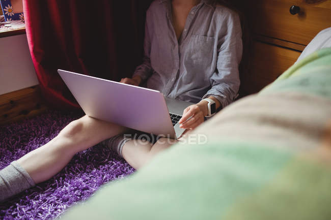 Середина жінки, використовуючи ноутбук вдома — стокове фото